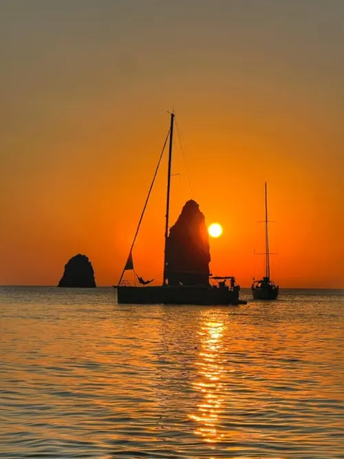 Baia di Lipari al tramonto con i faraglioni e Vulcano sullo sfondo